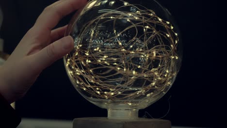 Woman hand touches a magic, glass ball. Dark, close up shot