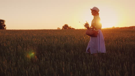 Romantic-Woman-With-Bouquet-Of-Wildflowers-Walking-On-The-Field-At-Sunset-Back-View-4K-Video
