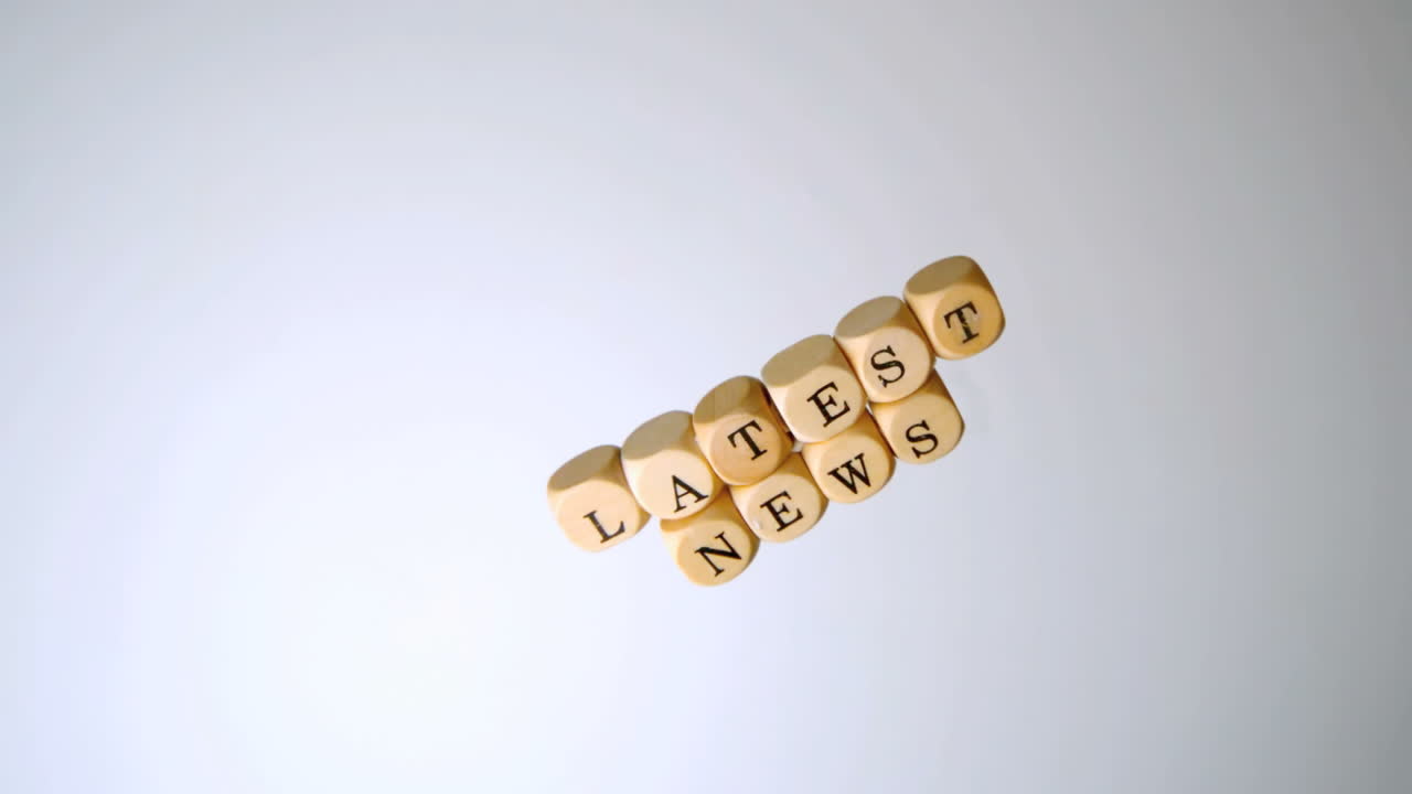 las últimas noticias escritas en dados que caen en la superficie blanca