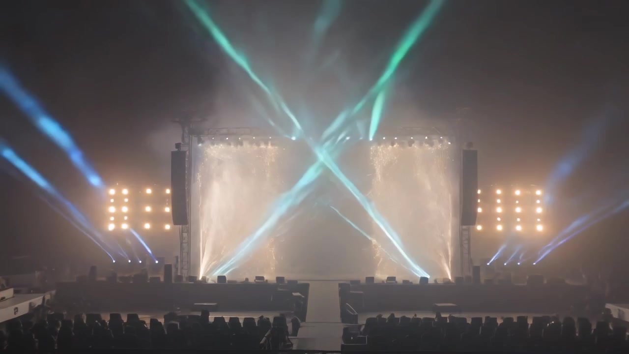 Activating fixtures, stage lighting forming X beams over runway in hall, ending with golden plumes