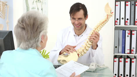 chiropractor showing spine model to his patient