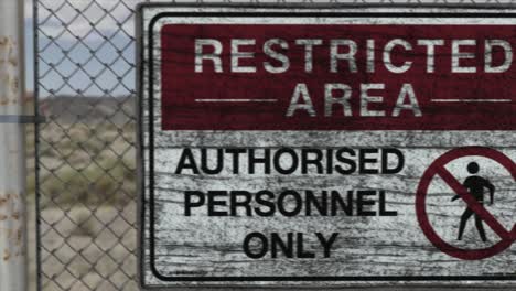 high quality 3d cgi render of a chainlink fence at a high security installation in a desert scene, with a restricted area - authorised personnel only sign