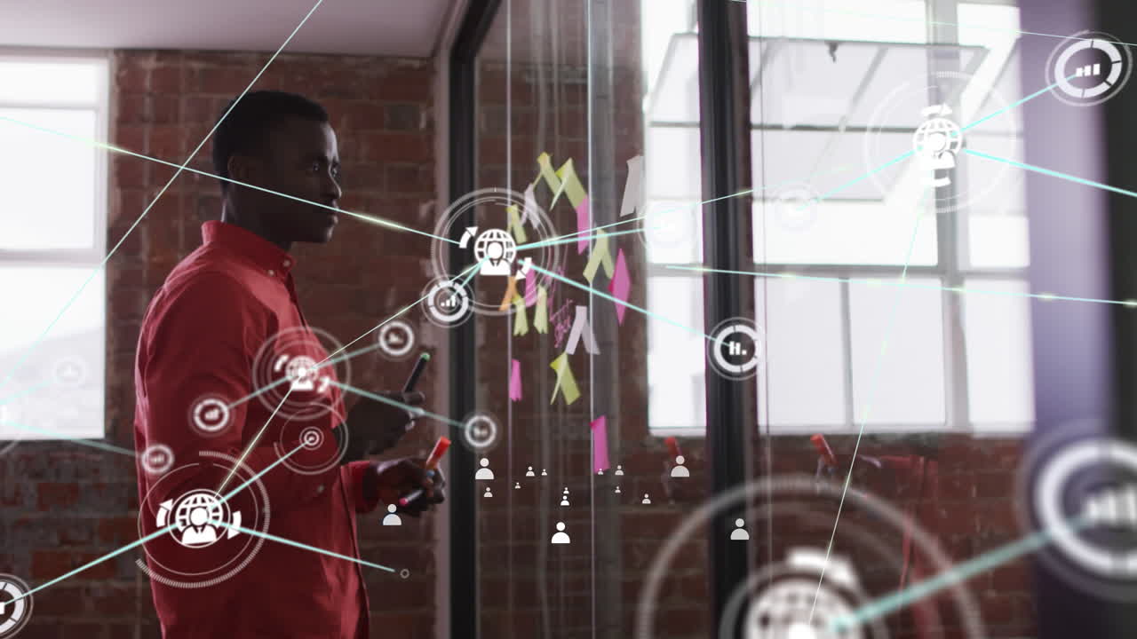 Animation of network of connections with icons over african american businessman in office
