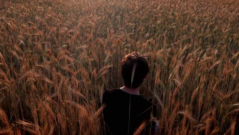 joven sentado y relajándose entre la lluvia en un campo al amanecer, al atardecer