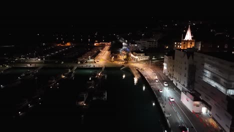 vuelo por la noche a lo largo de la costa iluminada de st. peter port en guernsey sobre victoria marina, albert marina y mirando hacia el sur esplanade con la estatua del príncipe alberto