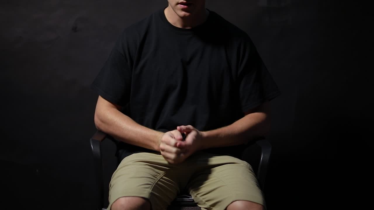 의자에 앉아 손을 비비는 남자의 슬로우 모션 샷