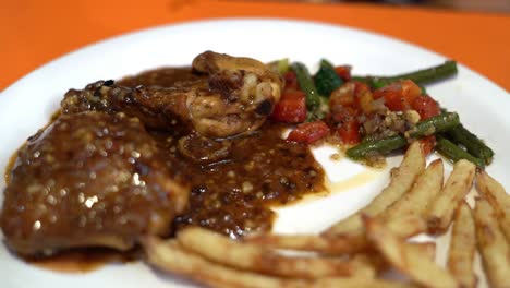 Close-up-view-of-roasted-chicken-with-fried-asparagus,-carrot,-potatoes,-red-pepper-and-rosemary