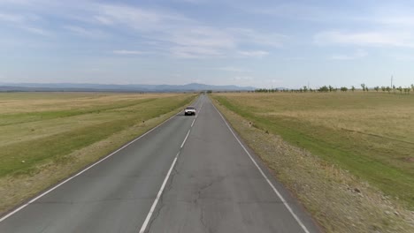 a car drives down a country road