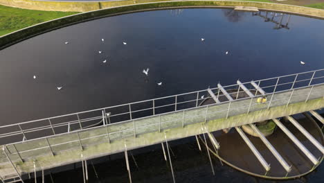 aerial view circling bridge crossing waste water circular sewage filtration tank close up