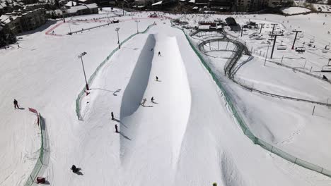 Excellent-Aerial-View-Of-People-Skiing-And-Snowboarding-On-A-Half-Pipe-At-Steamboat-Springs,-Colorado