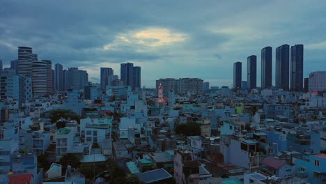 early morning drone fly in over modern urban rooftops towards illuminated french colonial catholic church
