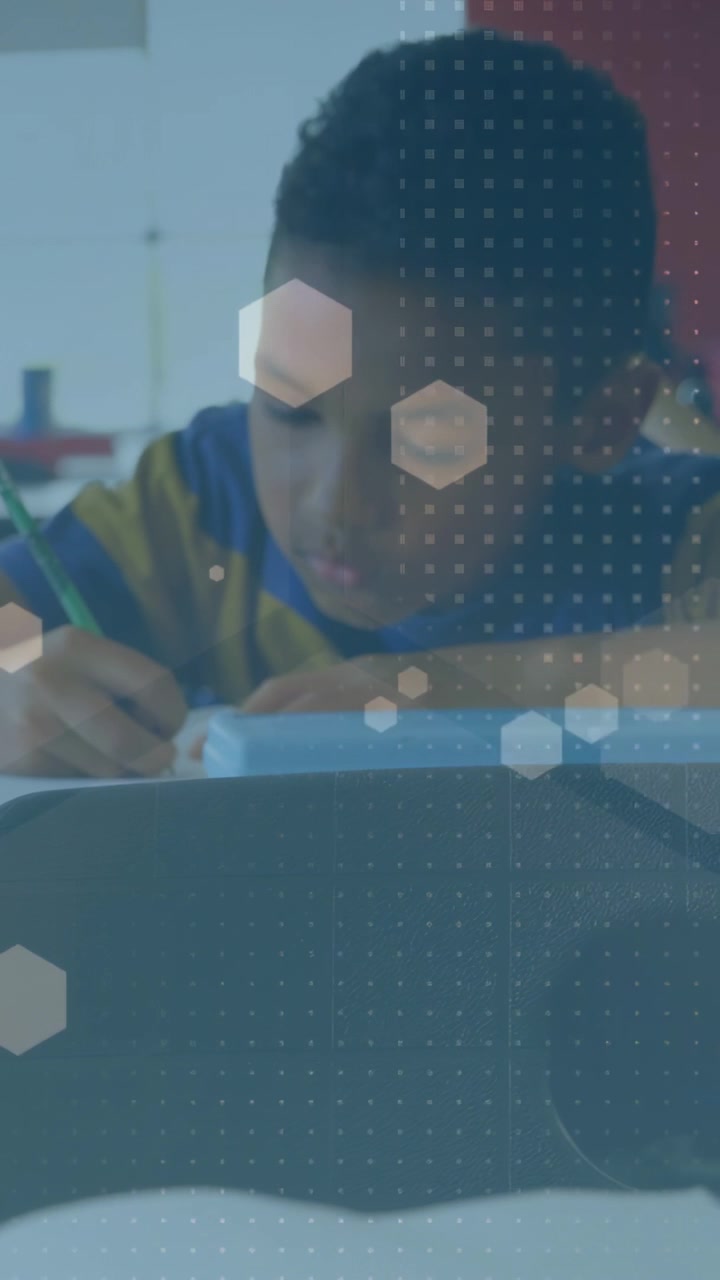 Vertical video: Male student writing classwork as lens tightening and hexagon overlay guiding focus