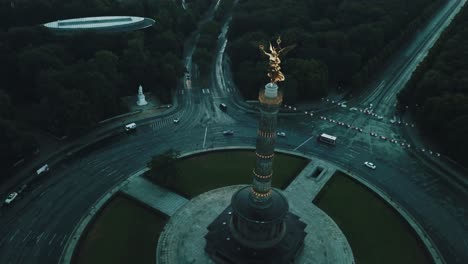 Drohnenantenne-Der-Berliner-Siegessäule-Vor-Sonnenaufgang-Mit-Bäumen-Ringsum-Und-Autos-Im-Kreisverkehr