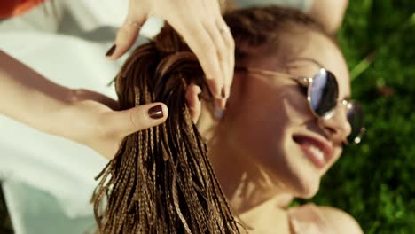 Trendy-hipster-girls-relaxing-on-the-grass-in-park.-Summer-lifestyle-portrait-of-two-hipster-women-lying-on-the-grass,-enjoying