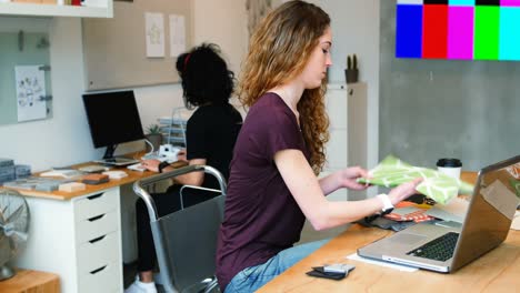 executive using laptop while checking sample