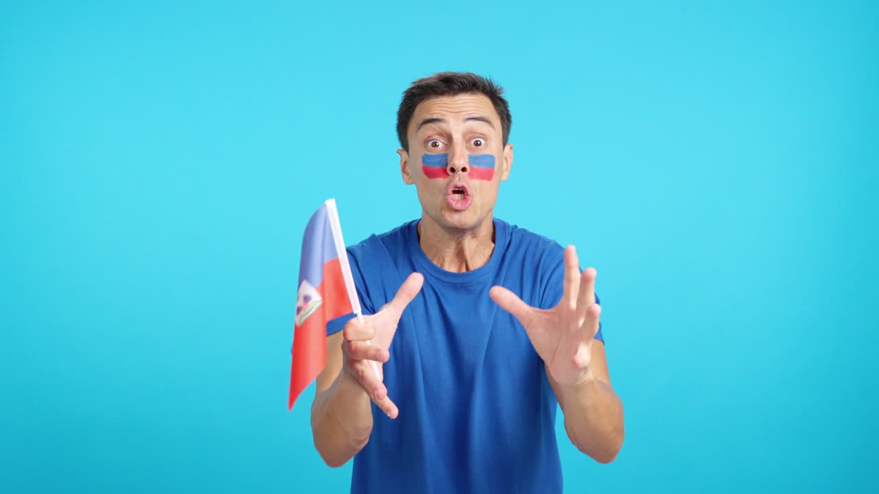 Man cheering for Haiti screaming and waving a national flag