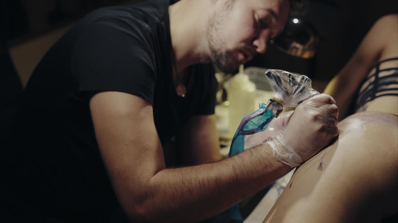 Tattoo artist working on a client's tattoo