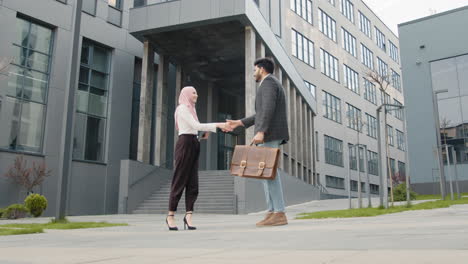 business handshake outside modern office building