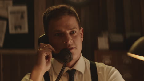 hombre hablando por teléfono vintage en una oficina retro