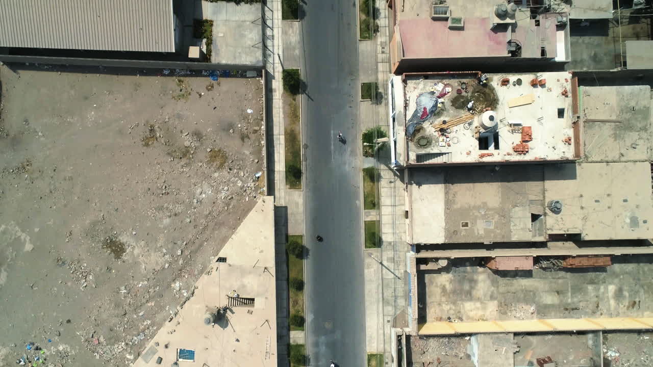 un drone central volando por encima de personas patinando en las calles de la ciudad de huacho, perú