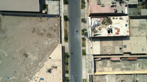 Cenital-drone-shot-flying-above-people-skating-on-the-streets-of-Huacho-city,-Peru