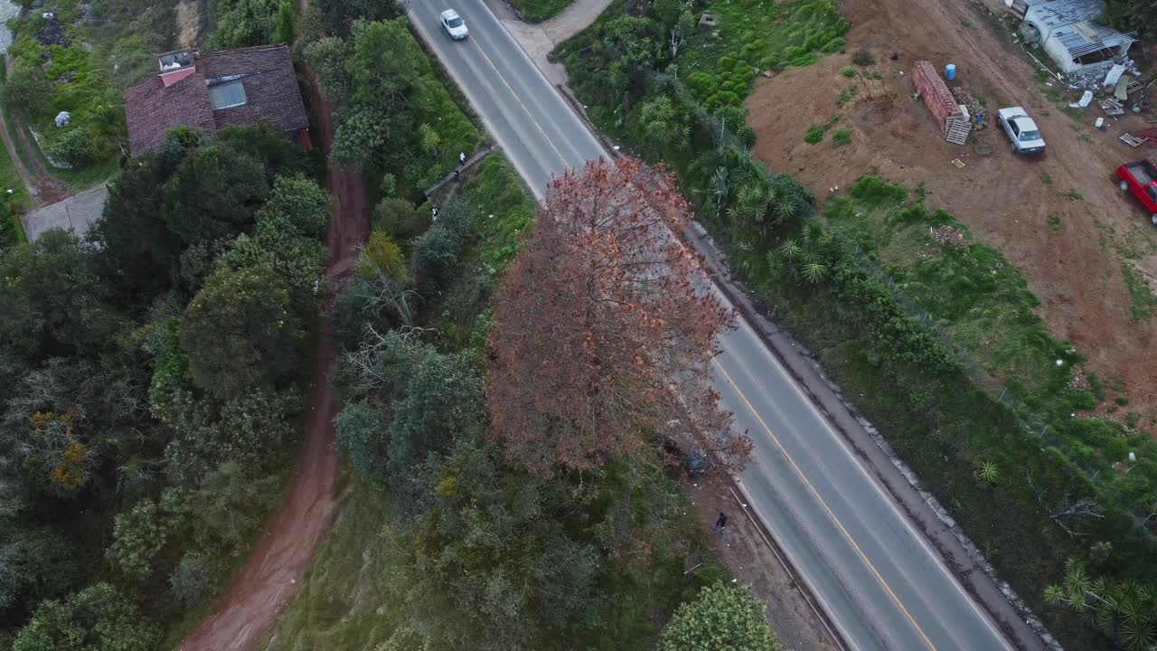 Aerial top shot of a highway road with rural countryside greenery and neighbourhood.