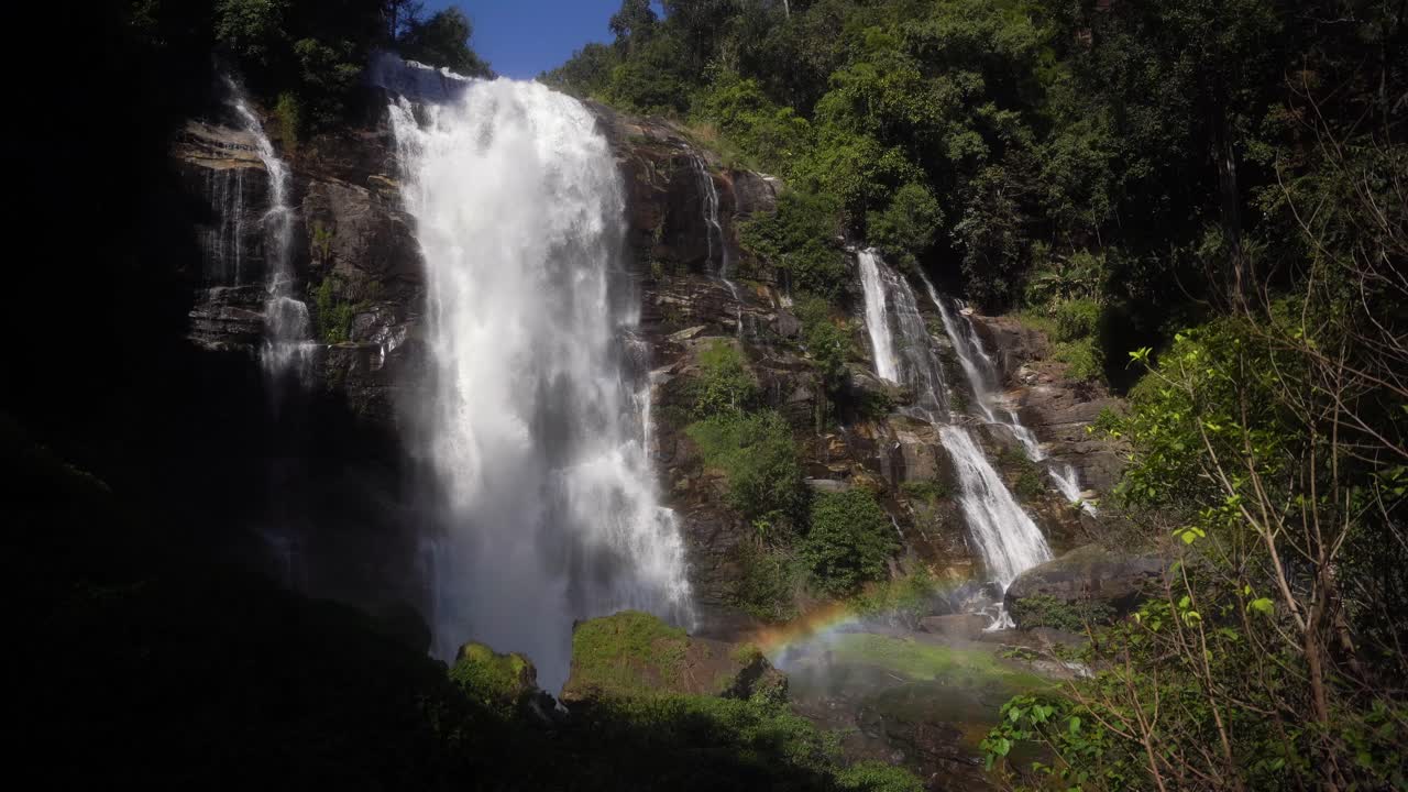 hermosa cascada alta de wachirathan donde cae mucha agua y la niebla crea un hermoso arco iris a través de la luz del sol, el agua brilla en tailandia