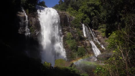 beautiful high wachirathan waterfall where a lot of water pours down and the mist creates a beautiful rainbow through the sunlight water shines through in thailand