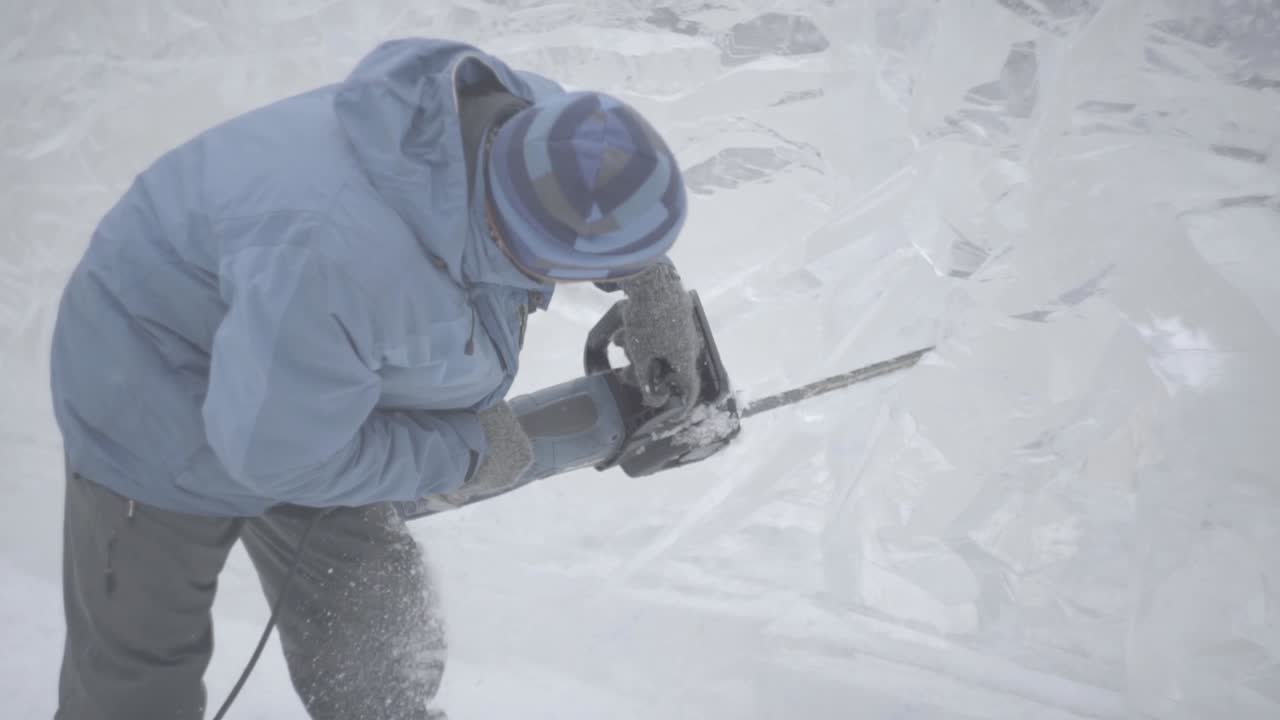 художник, резящий на льду с помощью бензопилы