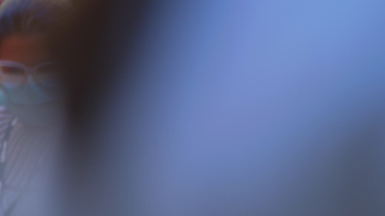 una joven con una máscara lleva un ramo de tulipanes a un hospital durante una visita