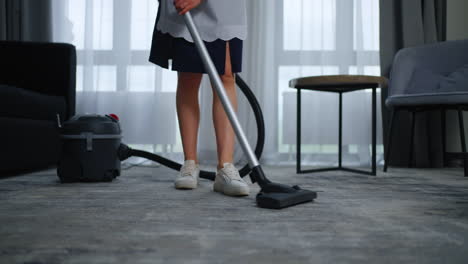 maid cleaning a hotel room with a vacuum cleaner