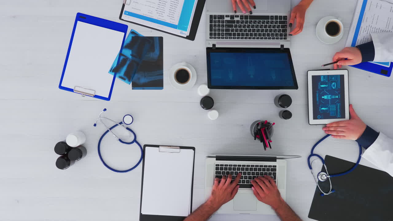 médicos discutiendo señalando en la tableta, vista de arriba