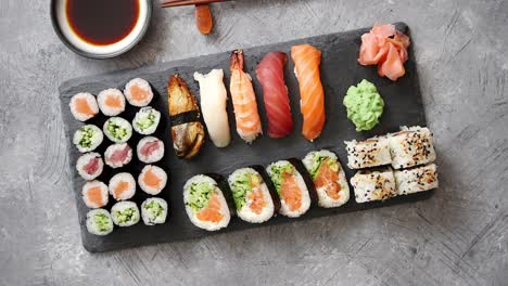 composition of different kinds of sushi rolls placed on black stone board