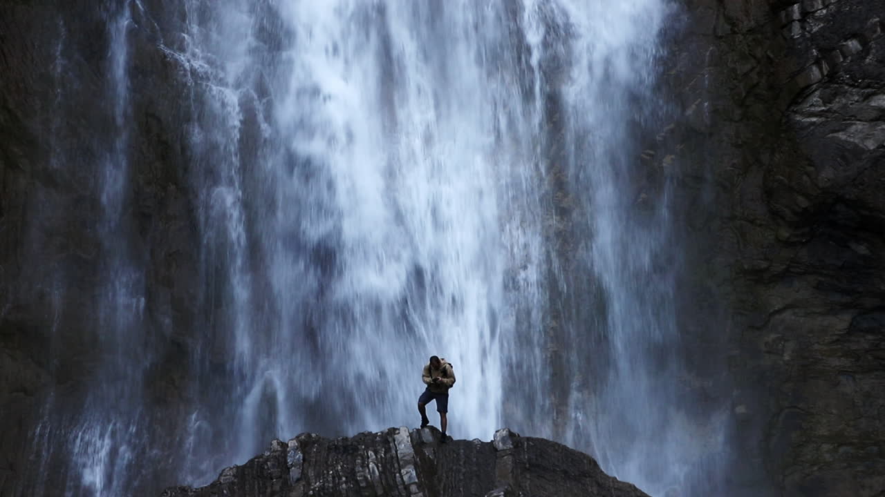Photographer taking a extra step for a picture at Sorrosal waterfalls