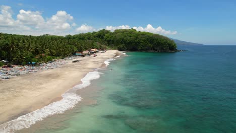 Beautiful-turquoise-ocean-waves-crash-at-tropical-Bali-Island-in-Pantai-Prasi-on-sunny-day,-aerial