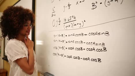 estudiante confundido mirando las matemáticas en la pizarra