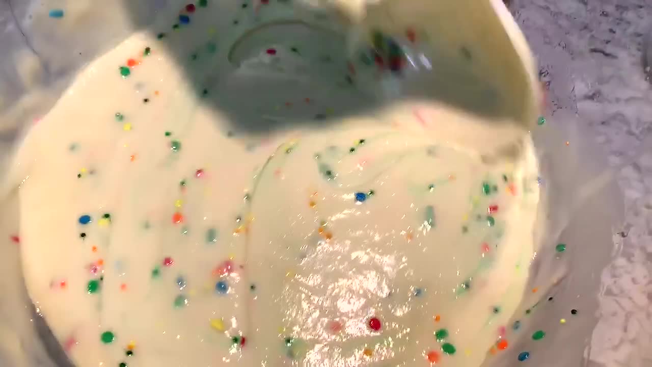 revolviendo a mano la masa de pastel funfetti en un tazón grande