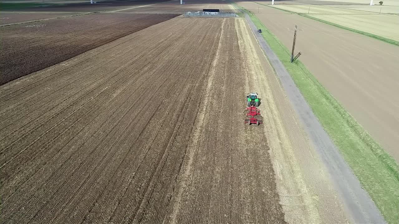 una vista aérea a la altura de un tractor mientras avanza por un campo labrando la tierra para prepararla para la próxima cosecha