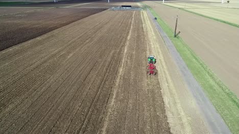 Eine-Luftaufnahme-Aus-Der-Höhe-Eines-Traktors,-Der-Ein-Feld-Hinunterfährt-Und-Das-Land-Bestellt,-Um-Es-Für-Die-Nächste-Ernte-Vorzubereiten