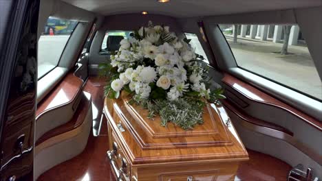 closeup shot of a funeral casket in a hearse or chapel or burial at cemetery