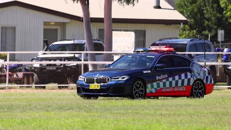 police vehicle driving past houses and parked cars