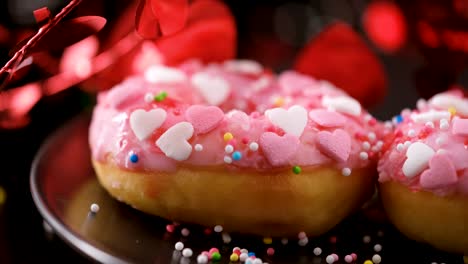 heart shaped sprinkled pink donuts. sliding shot