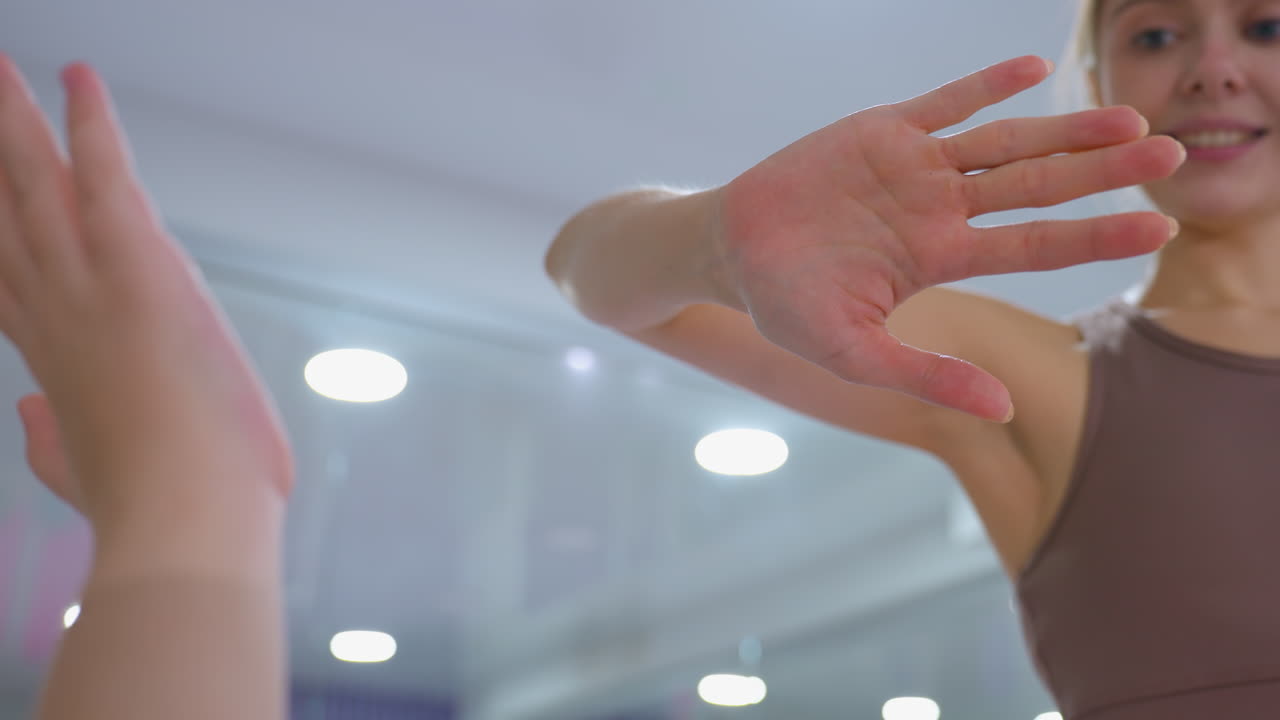 primer plano de una mujer dando un high five a un amigo en un ambiente de fitness brillante, capturando el entusiasmo, el trabajo en equipo, la motivación y el apoyo durante una sesión de entrenamiento