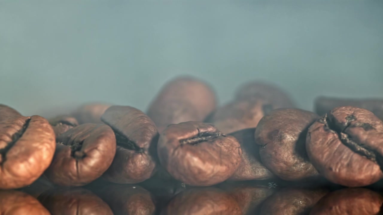 Nærbillede af friskristede kaffebønner med stigende damp