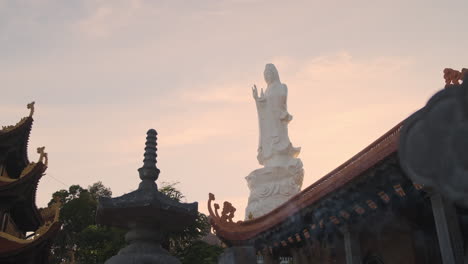 large white statue at a vietnamese temple at sunset