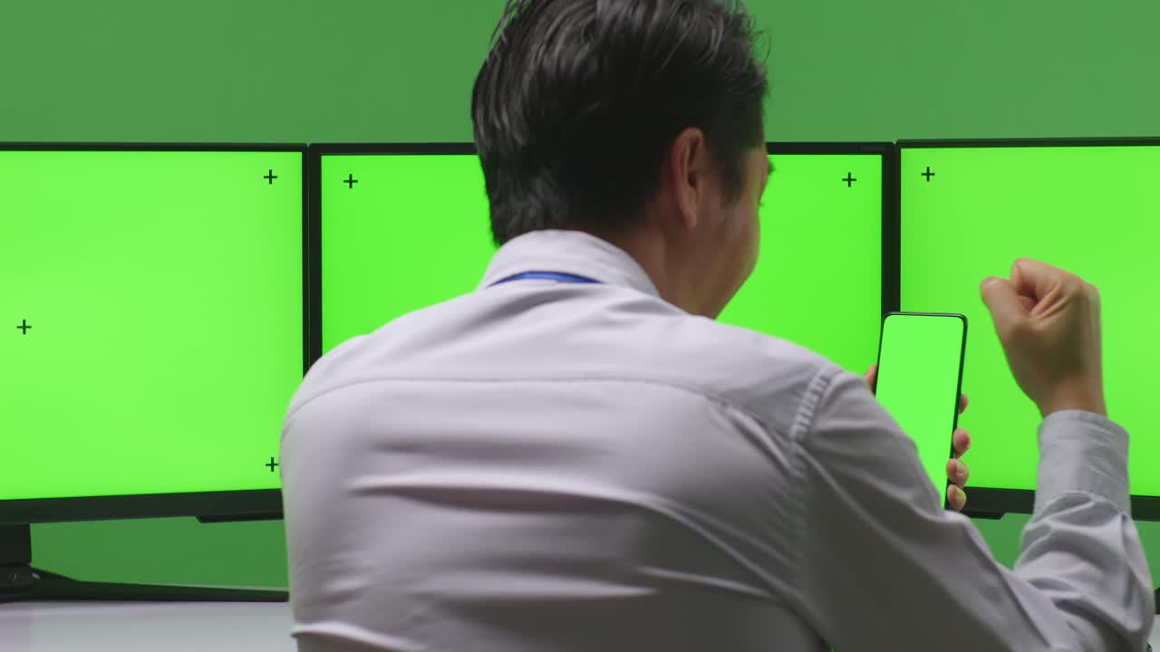 여러 컴퓨터 모니터 앞에서 성공을 축하하는 사업가