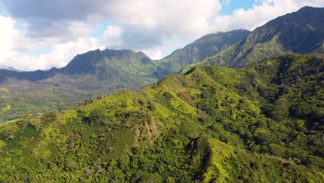 cinematic aerial shot of hanalei bay and green mountains with a waterfall in kauai, hawaii