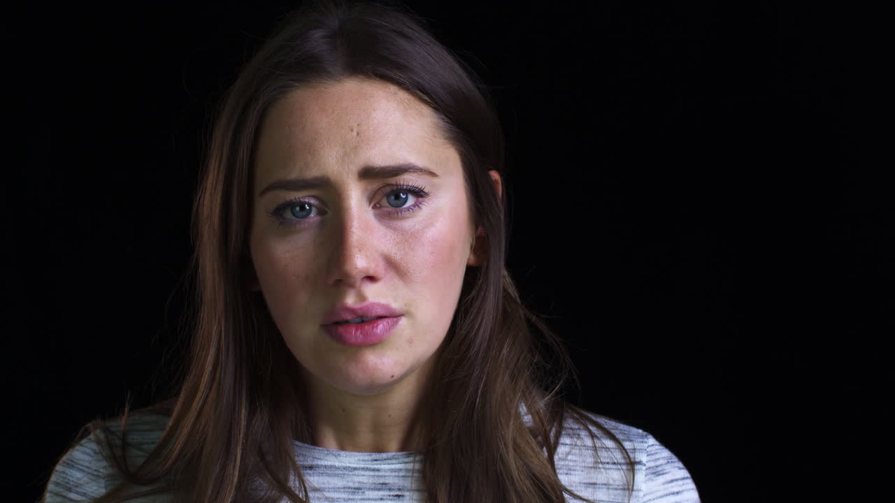슬프게 카메라를 바라보는 불행한 젊은 여성의 클로즈업