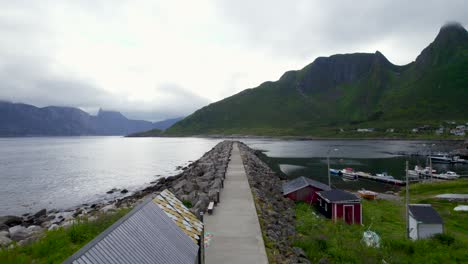 Flying-low-over-the-breakwater-of-Mefjordvar-on-a-overcast-day-with-a-scenic-Mountain-View