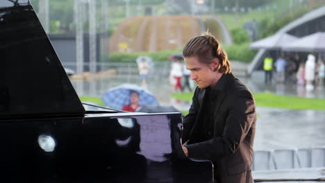 pianist playing piano outdoors in the rain